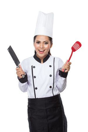portrait of Pretty woman Chef in action, hold spatula and knifeの写真素材