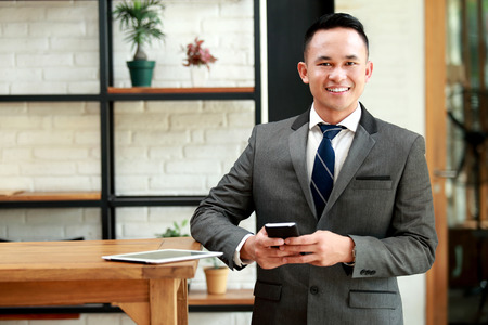 portrait of young businessman waiting for meeting appointment at cafeの写真素材