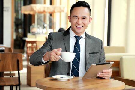 portrait of businessman taking a break at coffee shopの写真素材
