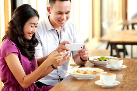 portrait of romantic young couple young couple taking photos of their food