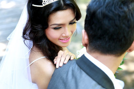 close up portrait of beautiful bride looking at her groom shoulderの写真素材