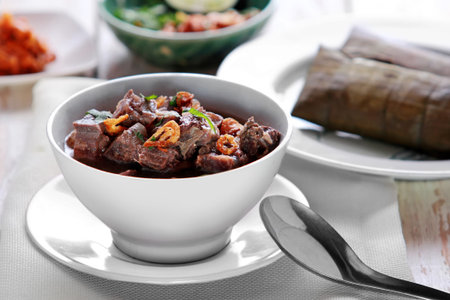 portrait of a bowl of coto makassar served with burasaの写真素材