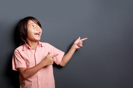portrait of little boy laughing and pointing at copy spaceの写真素材