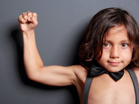 close up portrait of cute boy feel fit and strong with dark backgroundの写真素材