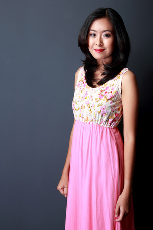 portrait of young beauty woman wearing pink floral long dressの写真素材