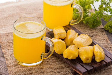 A potrait of a glass of jack fruit and milk smoothie