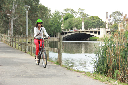 young beautiful woman riding a bicycle in city park river side. Active people. Outdoorsの写真素材
