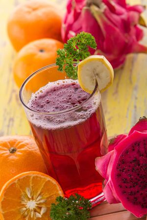 A potrait of a glass Red Dragon Fruit and Orange Smoothieの写真素材