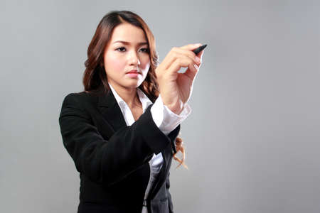 A portrait of a young businesswoman working on a virtual screenの写真素材