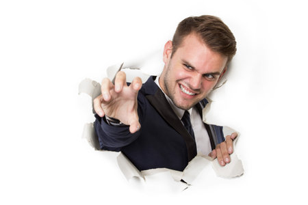 A portrait of a young businessman break the blank white billboard