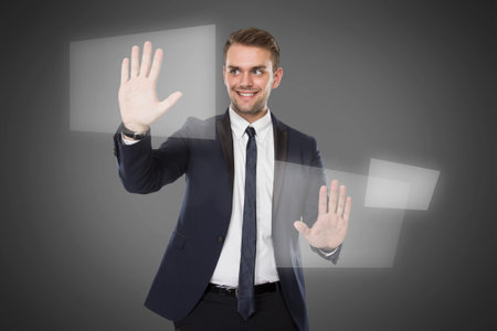 A portrait of a young businessman push againts virtual screen