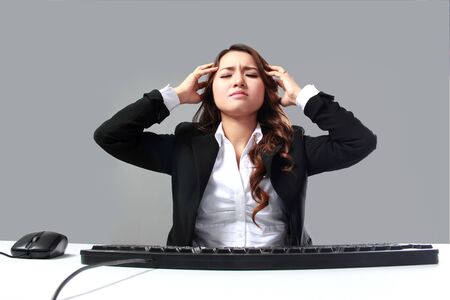 portrait of working hard businesswoman stressed using computerの写真素材