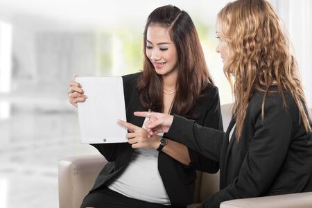 A portrait of a two young businesswoman wtih a clipboardの写真素材