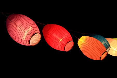 portrait of colorful paper lampions isolated in blackの写真素材