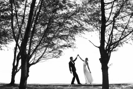 black and white photo of wedding couple dancing under the treeの写真素材