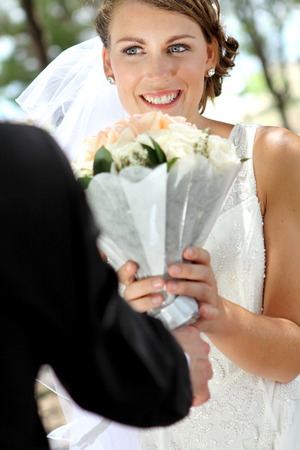 bride receive a bouquet from her groomの写真素材