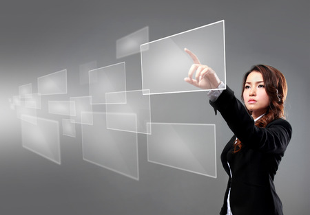 portrait of businesswoman pointing at floating screen using high technologyの写真素材