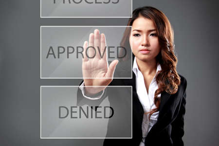 portrait of young businesswoman choose "approved" buttton on media screenの写真素材