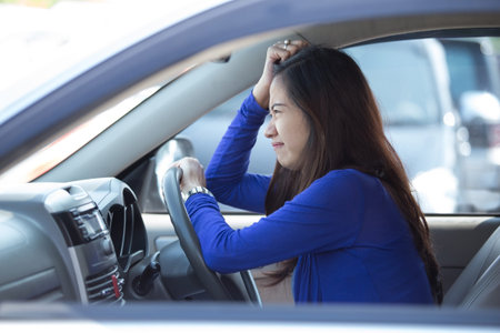 A portrait of a young asian woman on a ride, a car, frustratedの写真素材