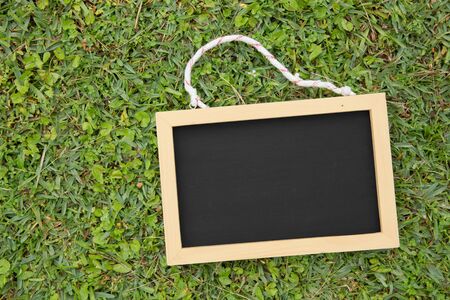 A portrait of a mini black chalkboard on grass yard backgroundの写真素材