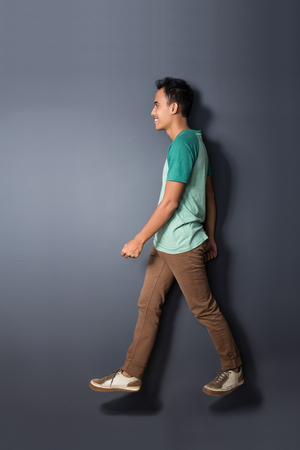 full body portrait of young man walking in the airの写真素材