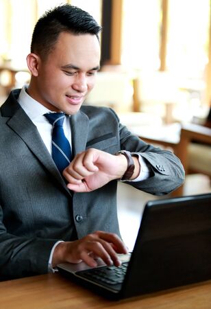 portrait of young businessman looking at his watchesの写真素材