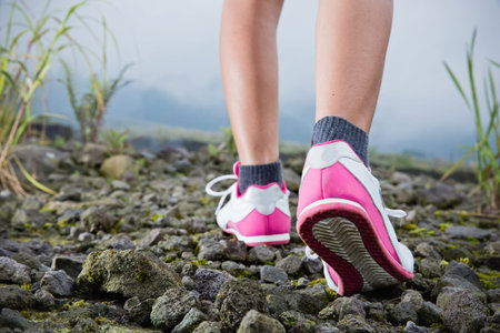 A portrait of trekking on the rocky road, foot close up