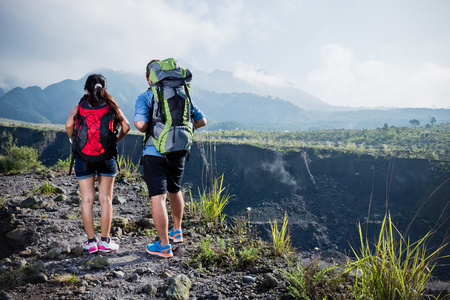 A portrait of a mixed couple go trekking together, nature backgroundの写真素材