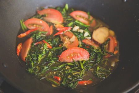 A portrait of stir-frying kale with tomato, close upの写真素材
