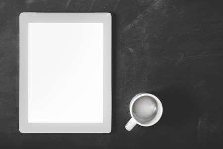 top view blank screen touchpad and coffee cup with copy space on black board for backgroundの写真素材