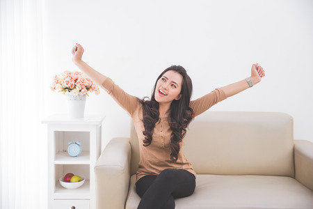 Woman happily rise her both hands up, winning gesturingの写真素材
