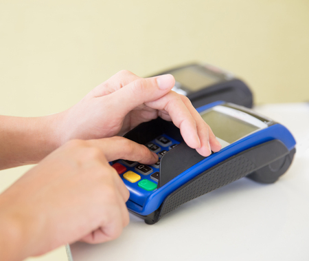 A portrait of EDC ( electronic Data Capture) machine, hand pressing password on itの写真素材