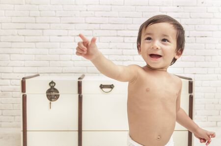 close up portrait of adorable toddler walking while pointing at somethingの写真素材