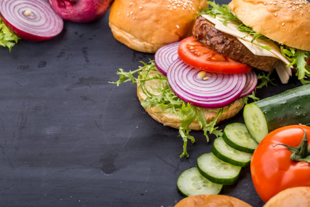 top view of homemade burger ingredients on black board with copy spaceの写真素材