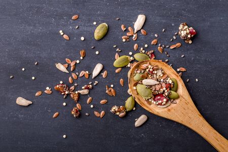 portrait of healthy cereal grains on wooden spoon with black board for backgroundの写真素材
