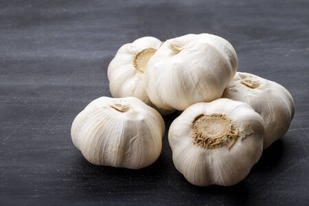 full frame portrait of fresh garlic on black board for tableの写真素材