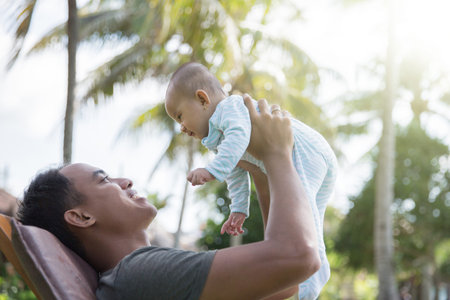 portrait of a father having fun with his baby on a sunny day