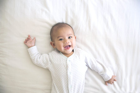 portrait of a happy cute baby smiling lying on a bed