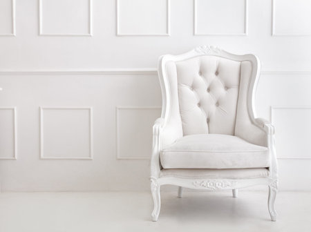 portrait of white vintage style armchair on white patterned wall with copy space