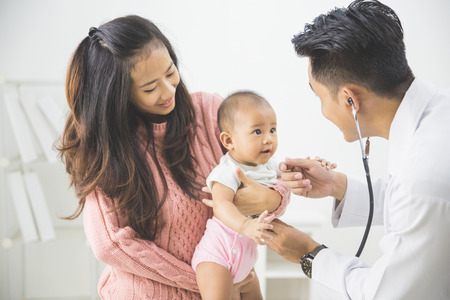 portrait of a baby being checked by a doctor using a stethoscopeの写真素材