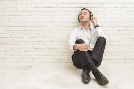 full body portrait of young businessman enjoy listening music using headphones with copy space on...