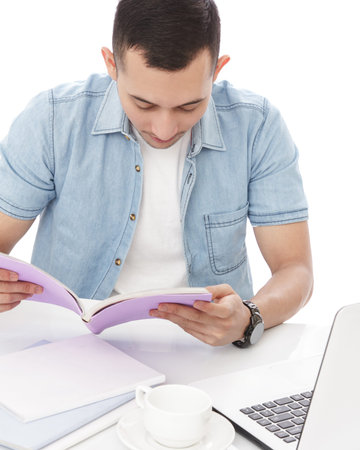portait of casual man focus reading a book isolated on white backgroundの写真素材