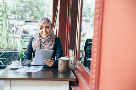 Young businesswoman on a coffee break. Using tablet computerの写真素材