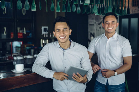 portrait of Young business owner and team partner with tablet in cafe