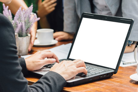 close up of hand of businessman busy working with team at a cafe | focus on laptopの写真素材
