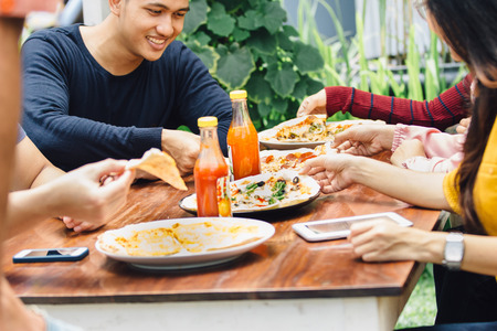 Group Of Young Friends Enjoying Meal In Outdoor Restaurantの写真素材