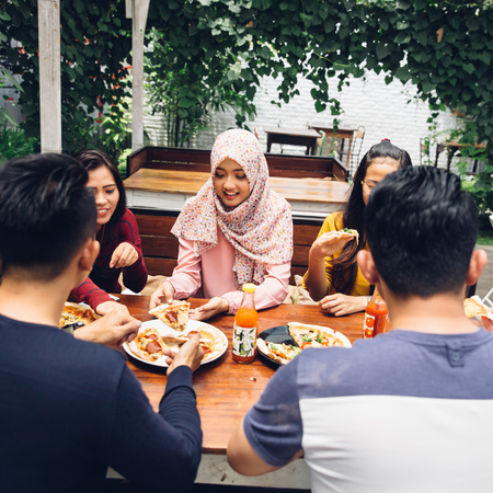 Group Of Young Friends Enjoying Meal In Outdoor Restaurantの写真素材