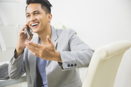 Portrait of asian young businessman talking to the phoneの写真素材