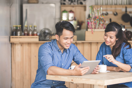 portrait of two young business partner using tablet together in the cafeの写真素材