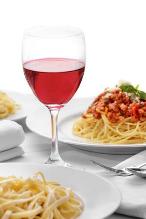 portrait of red wine on glass with italian pasta cuisine isolated on white backgroundの写真素材